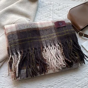 Detail of vintage plaid scarf with long tassels and soft woven texture in warm tones