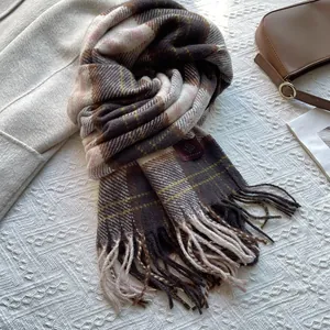 Detail of classic plaid scarf with long fringe trim in soft coffee and pink tones