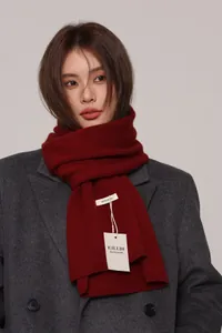 Close-up of dark red 100% Australian wool scarf with fine knitted texture and label