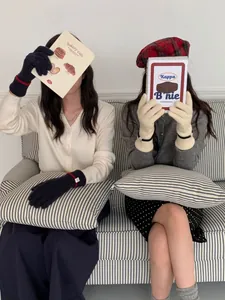 Gants en cachemire tricotés en noir et beige avec poignets rayés sur les mannequins
