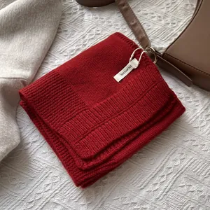 Detalle de bufanda de lana 100% pura roja con textura de punto acanalado de calidad