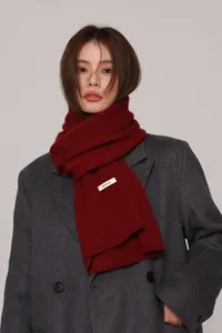 Close-up of a 100% pure Australian wool knitted scarf in deep red on a female model