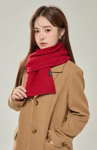 Detail of red 100% wool scarf showing heavy cable knit texture and material tag