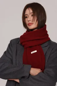 Close-up of 100% pure wool scarf in deep burgundy red with soft knitted texture