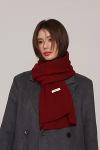 Detail of deep red 100% Australian wool knitted scarf with official material label