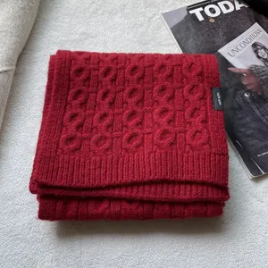 Deep red 100% wool knitted scarf with geometric ring pattern and ribbed edge finish