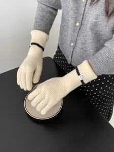 Détail de gants en cachemire tricotés blanc crème avec poignets côtelés et rayure