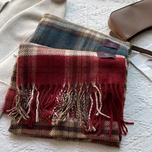 Close-up of vintage plaid scarves with tassels and premium brand label on white fabric