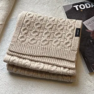 Detail of premium beige 100% wool cable knit scarf with high-quality texture