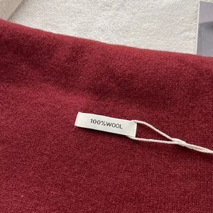 Close-up of dark red 100% pure wool scarf showing rich texture and official label