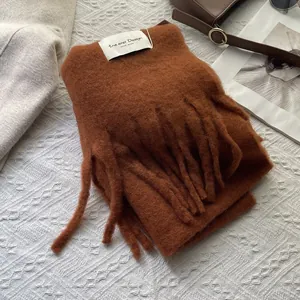 Detailed texture of caramel brown cashmere scarf with fringe and woven label