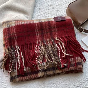 Detail of red and brown plaid scarf with fringe texture and warm woolen material