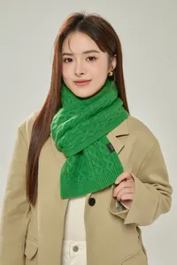 Detailed macro view of green 100% wool chunky knit scarf with thick cable stitch texture