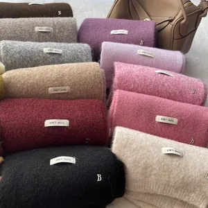 Close-up of soft wool knit scarves in multiple colors with ERET WOOL fabric labels