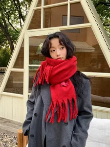 Close-up of vibrant red knit scarf with long fringe tassels for winter warmth