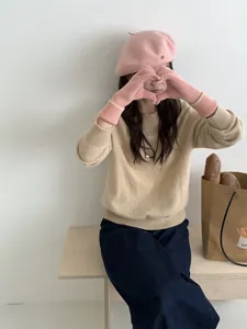 Gros plan de gants d'hiver en tricot rose portés par un mannequin dans une tenue décontractée