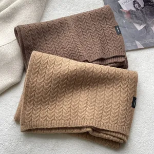 Dettaglio di sciarpe in 100% pura lana con trama a trecce marrone e cammello