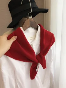 Détail d'un foulard triangle en tricot rouge avec texture en laine sur cintre