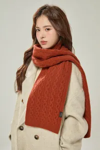 Detail of 100% wool knitted scarf in pumpkin orange with premium cable knit texture