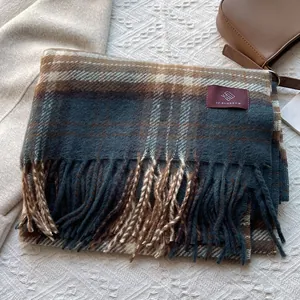Close-up of retro plaid scarf with soft fringe details and brand woven label