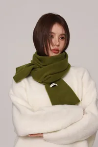 Detailed view of dark green 100% pure wool scarf with fabric composition label
