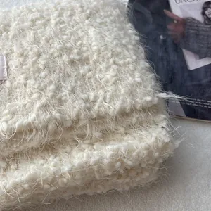 Close-up of fluffy cream plush knit scarf texture with soft mohair feel and premium finish
