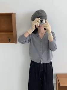 Détail de gants en tricot chauds avec poignets rayés bleus et petite étiquette décorative