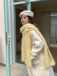 Close-up of soft creamy yellow fluffy scarf with luxurious long faux fur texture