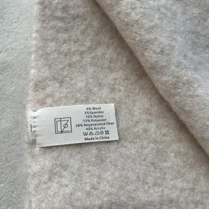 Macro shot of product care label detailing soft wool blend material and fabric texture