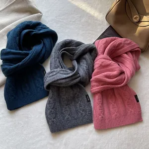 Detailed cable knit texture of three wool scarves in navy blue, grey and soft pink colors