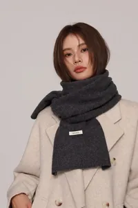 Detailed texture of dark grey 100% pure wool scarf paired with a wool coat