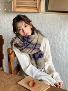 Close-up of warm plaid scarf with tassels and thick retro check pattern knit
