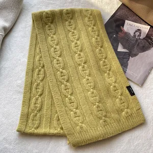 Detailed view of green wool scarf with chunky knit pattern and 100% WOOL label