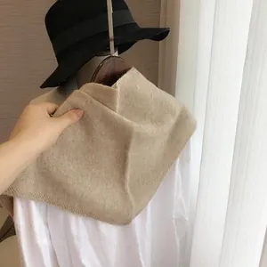 Gros plan d'un foulard triangle en maille beige montrant la texture sur un mannequin