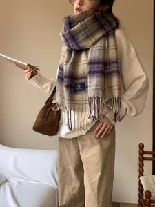 Detail view of retro plaid scarf with long fringe and soft woven texture in warm indoor setting