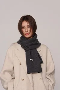 Close-up of 100% pure wool scarf in dark grey with authentic quality material label