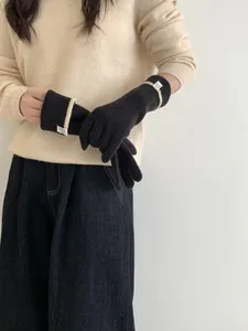 Détail de gants en tricot noir avec poignets rayés et doublure chaude pour l'hiver