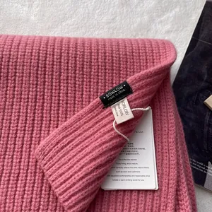 Nahaufnahme des Schals aus 100% reiner Wolle in Rosa mit Rippstrick und Markenetikett