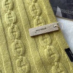 Close-up of 100% pure wool lime green knit scarf with thick chain texture and logo tag