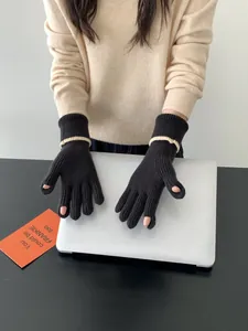 Détail de gants tricotés sans doigts pour écran tactile sur un ordinateur portable