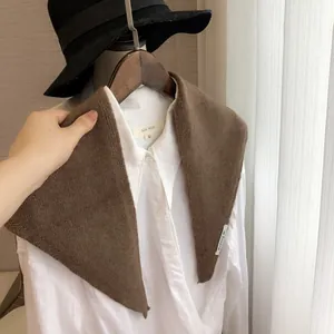 Détail de la texture d'un châle en tricot marron foncé avec étiquette de marque