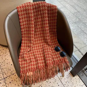 Detaillierte Makroansicht des weichen, dicken Stoffes und der Fransen am Hahnentritt-Schal