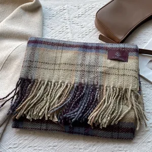 Detail of plaid scarf featuring fringed edges and soft texture on a lifestyle setting