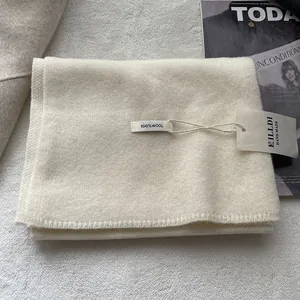 Ivory 100% wool scarf handmade winter wrap shown with fashion magazine on textured backdrop