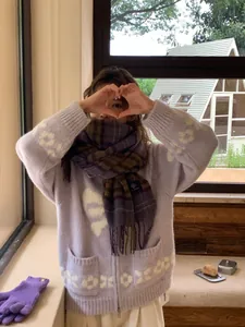 Close-up of purple plaid scarf with fringe and matching knit gloves in a winter set
