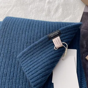 Detailansicht aus 100% reiner Wolle mit Rippstrickmuster sowie Marken und Materialetikett
