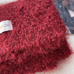 Macro shot of deep red wool-like plush fabric scarf with a minimalist OWLOW woven label