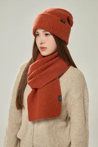 Detailansicht aus 100% Wolle: Rostrote Strickschal und passende Mütze an einem Model