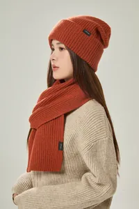 Makrodetail des gebrannten orangefarbenen 100% Wollschals und der Beanie mit Rippenstruktur