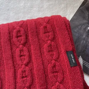 Detail of 100% pure wool scarf featuring thick cable knit and signature chaine d'ancre pattern